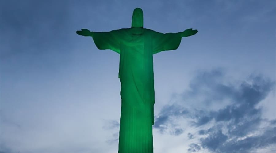 Imagem da famosa estátua Cristo Redentor no Rio de Janeiro, brasileira, conhecida por sua grandeza e importância cultural, vista contra um céu nublado.