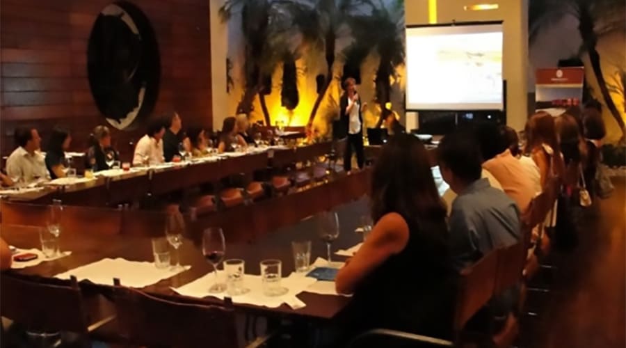 Corporate meeting or business event with several people seated around a long table, a presentation on a projected screen and an elegant atmosphere.
